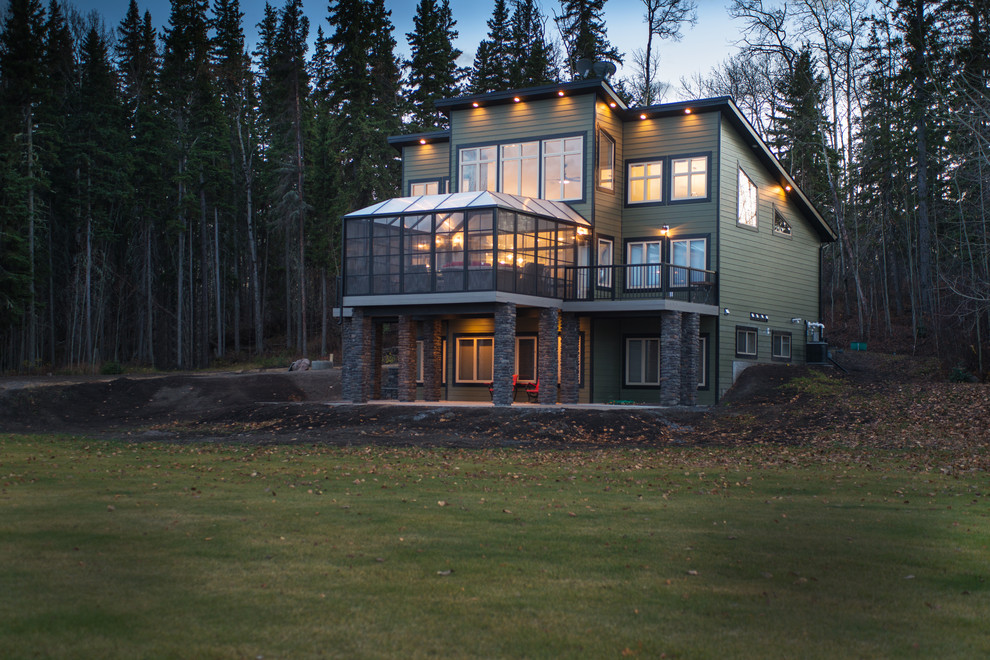 Esempio della casa con tetto a falda unica verde classico a due piani di medie dimensioni con rivestimento con lastre in cemento