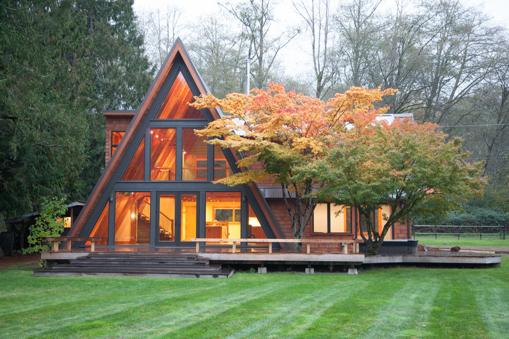 Imagen de fachada marrón rústica de una planta con revestimiento de madera y tejado a dos aguas