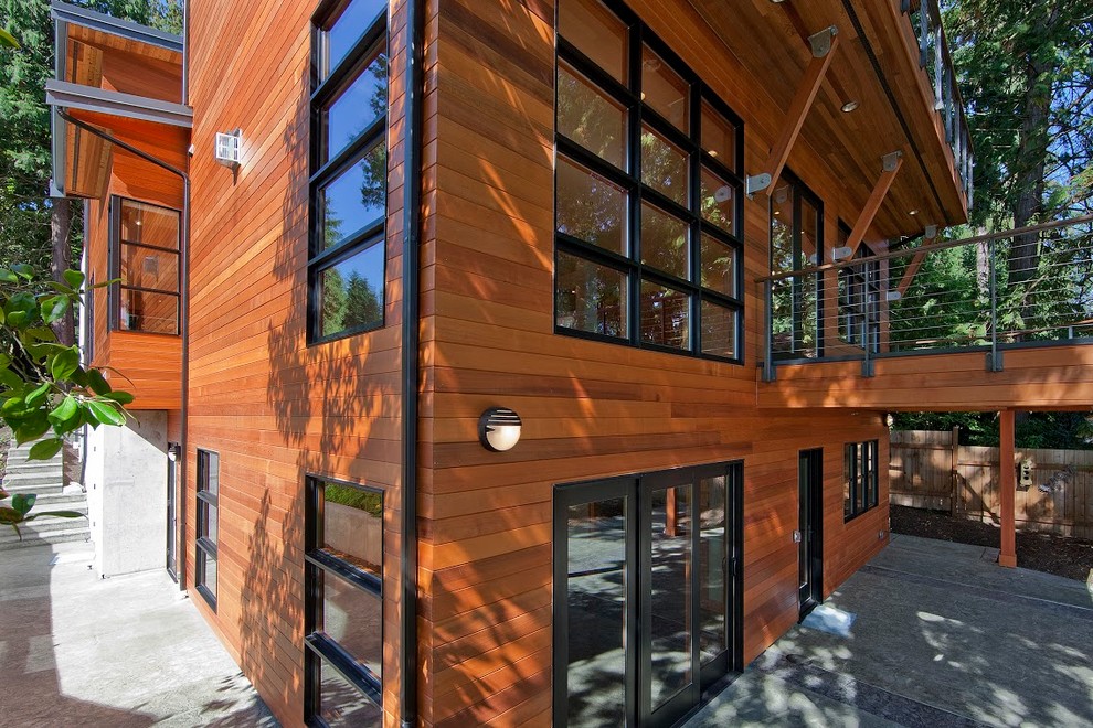 Idée de décoration pour une très grande façade de maison marron chalet en bois à deux étages et plus avec un toit plat.