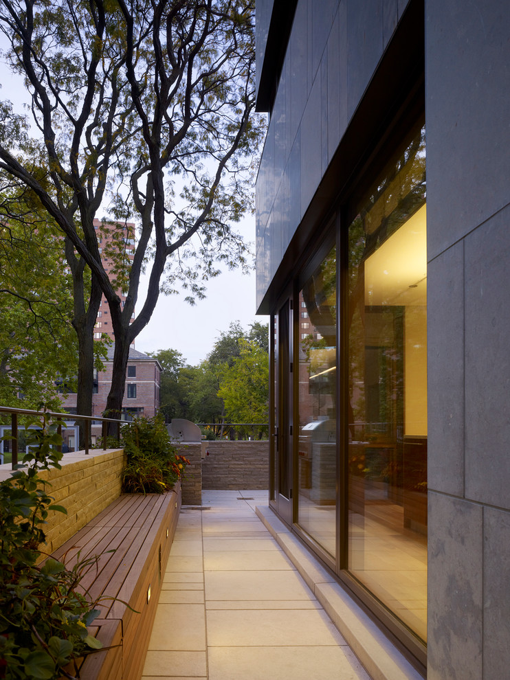 Mittelgroßes, Dreistöckiges Modernes Haus mit Steinfassade, grauer Fassadenfarbe und Pultdach in Chicago