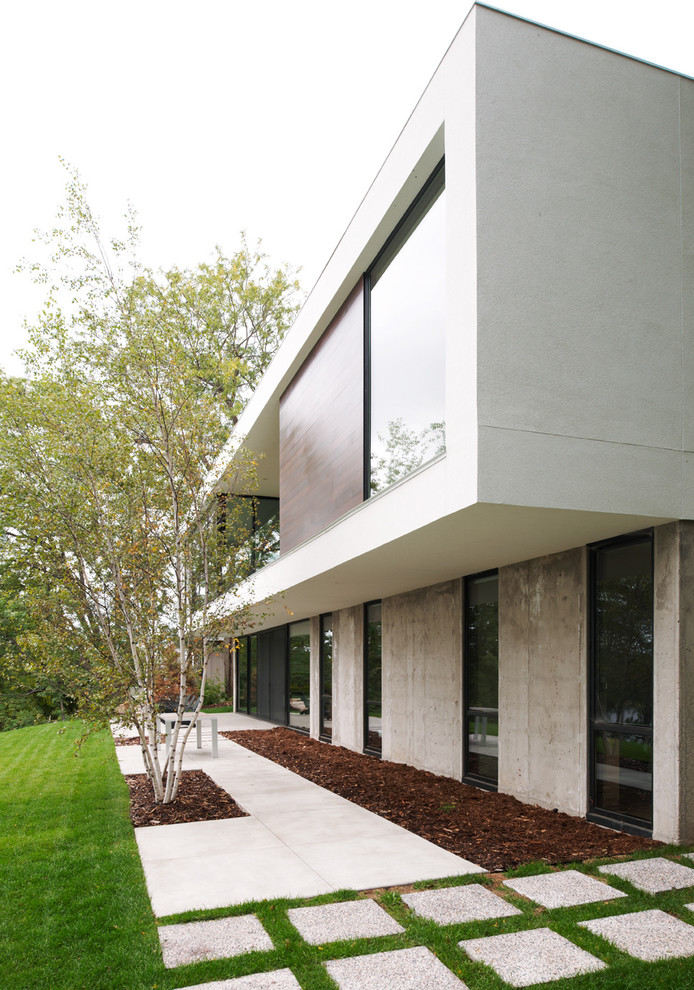 Modelo de fachada minimalista de tamaño medio de dos plantas con revestimiento de hormigón