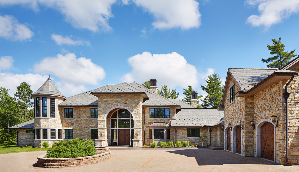 Inspiration for a beige and expansive classic two floor detached house in Minneapolis with stone cladding, a half-hip roof and a shingle roof.