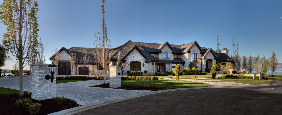 Ispirazione per la villa ampia beige vittoriana a due piani con rivestimento in pietra, tetto a capanna, copertura a scandole e tetto nero