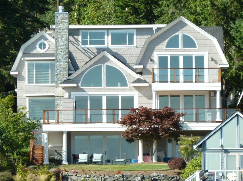 Großes, Dreistöckiges Maritimes Haus mit grauer Fassadenfarbe, Mansardendach und Schindeldach in Seattle