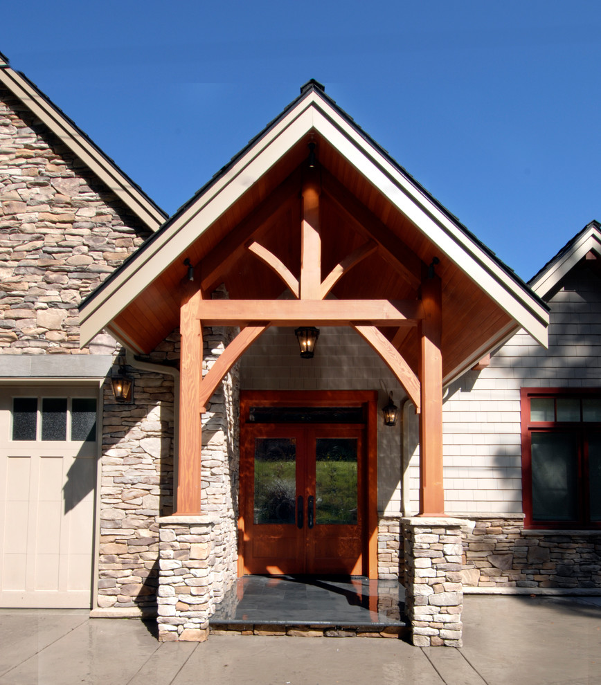 На фото: двухэтажный, коричневый дом среднего размера в стиле кантри с комбинированной облицовкой и двускатной крышей