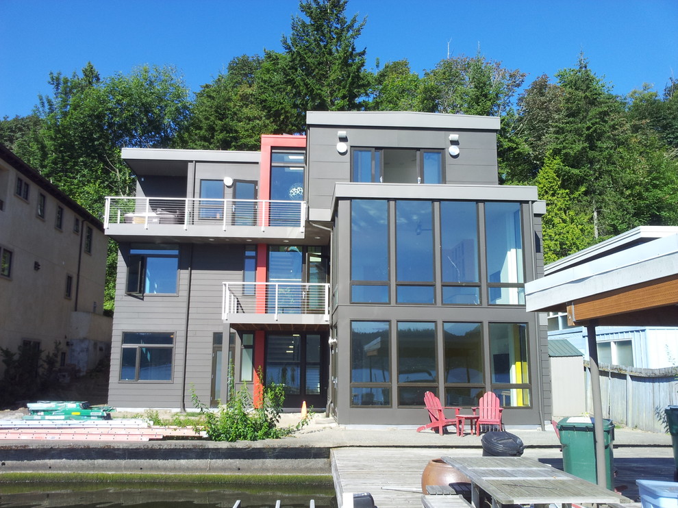 Gey and large contemporary house exterior in Seattle with three floors, concrete fibreboard cladding and a flat roof.