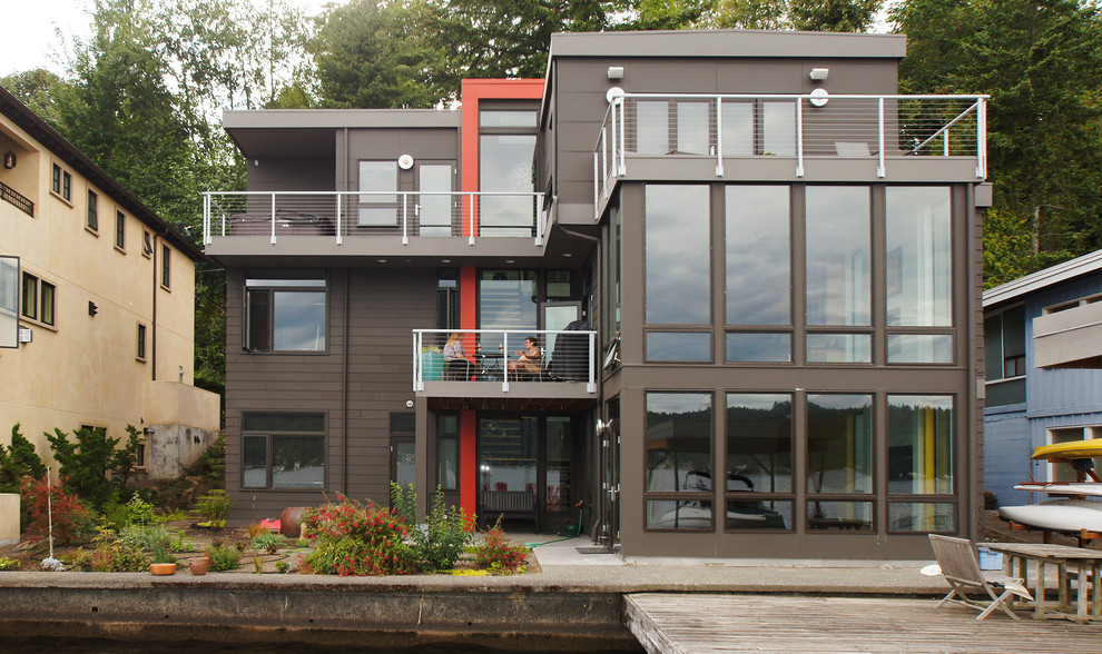 Diseño de fachada gris contemporánea grande de tres plantas con revestimiento de aglomerado de cemento y tejado plano