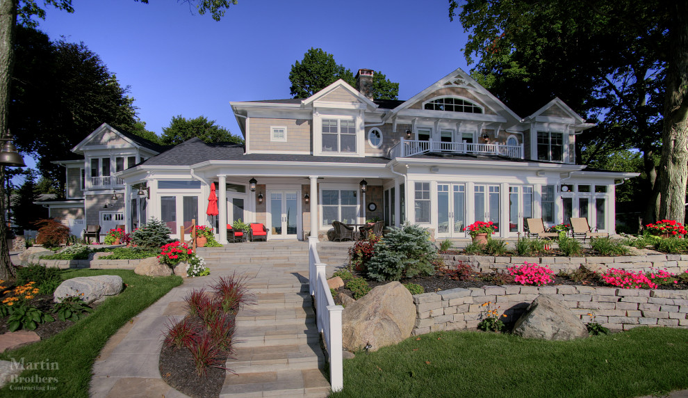Photo of an expansive nautical two floor detached house in Grand Rapids with wood cladding and a shingle roof.