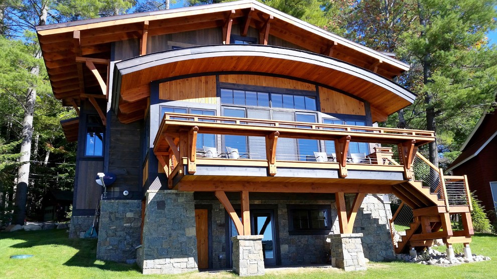 Cette photo montre une grande façade de maison marron tendance à deux étages et plus avec un revêtement mixte et un toit à deux pans.