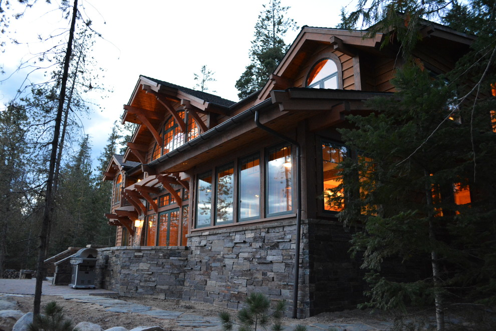 This is an example of a large rustic two floor house exterior in Seattle with wood cladding and a pitched roof.