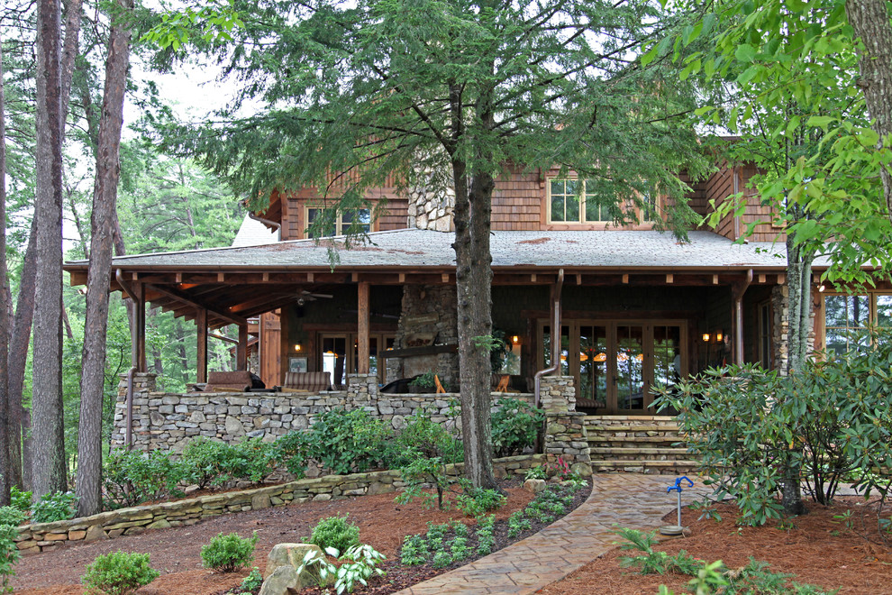 Aménagement d'une grande façade de maison marron montagne en bois à un étage.