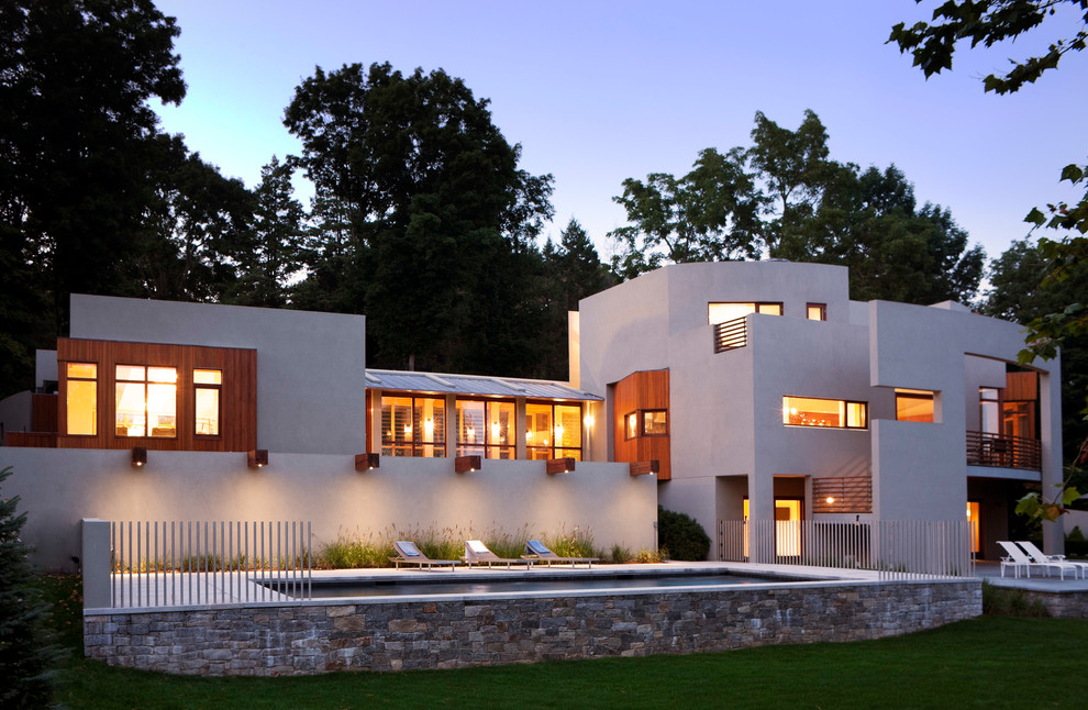 Diseño de fachada de casa blanca contemporánea extra grande de tres plantas con revestimiento de adobe y tejado plano