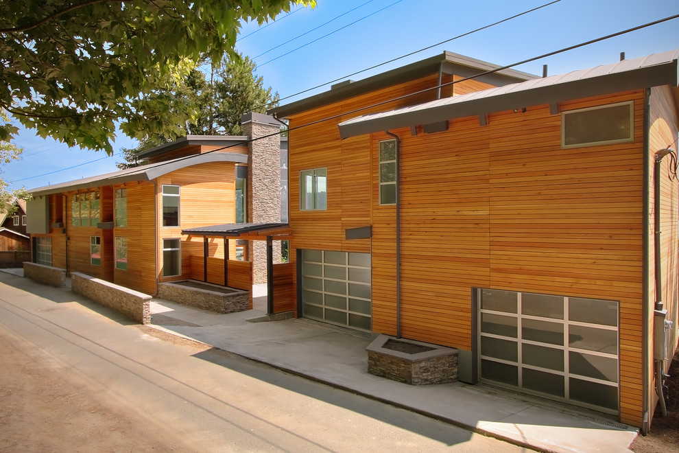 Diseño de fachada de casa pareada marrón actual grande de dos plantas con revestimiento de madera y tejado de metal