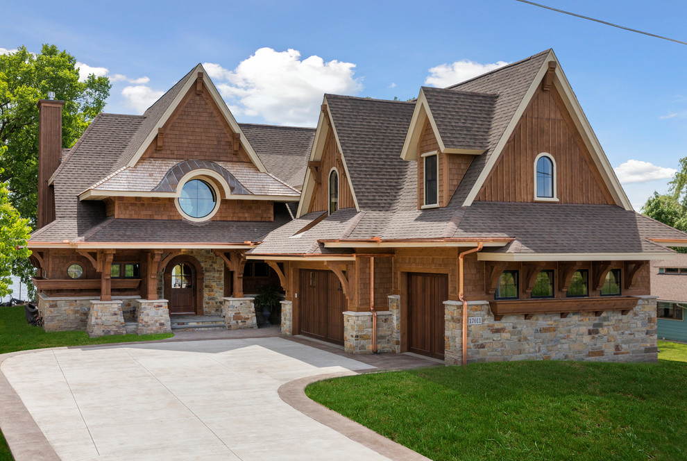 Cette image montre une grande façade de maison marron chalet en bois à un étage.