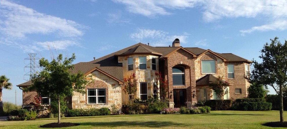 Example of a large beige two-story stone exterior home design in Other