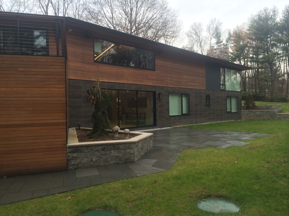 Idée de décoration pour une grande façade de maison design en bois à un étage avec un toit à deux pans.