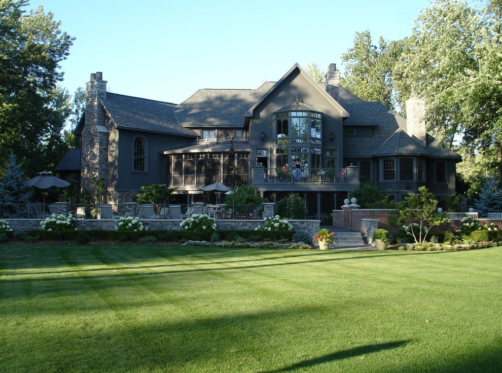 Exempel på ett mycket stort klassiskt grått hus, med tre eller fler plan, stuckatur och valmat tak