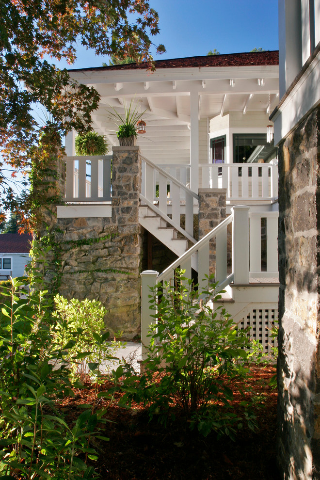 Foto della facciata di una casa ampia bianca rustica a tre piani con rivestimenti misti e tetto a capanna