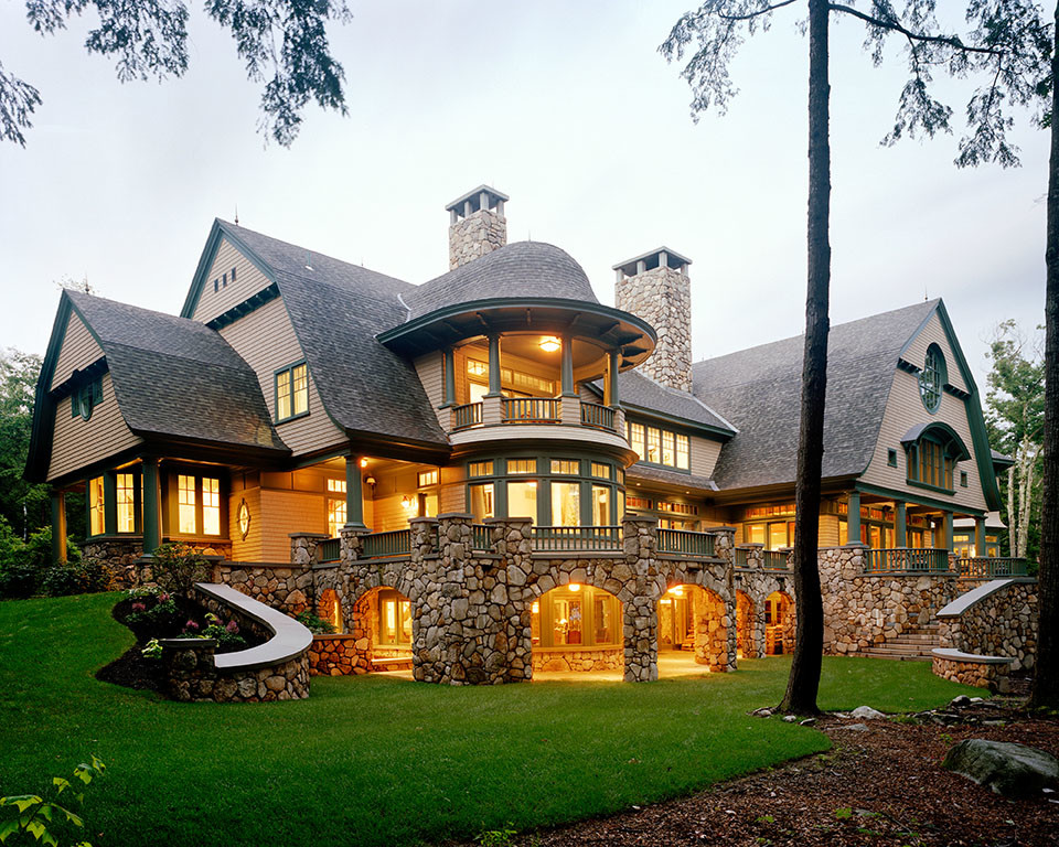 Cette image montre une très grande façade de maison marron chalet à deux étages et plus avec un revêtement mixte, un toit en appentis et un toit en shingle.