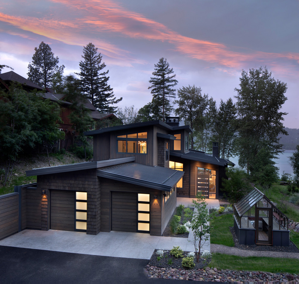 На фото: большой, двухэтажный, деревянный, коричневый частный загородный дом в современном стиле с односкатной крышей и металлической крышей с