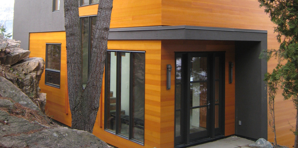 Imagen de fachada marrón contemporánea de tamaño medio de dos plantas con revestimiento de madera y tejado a dos aguas