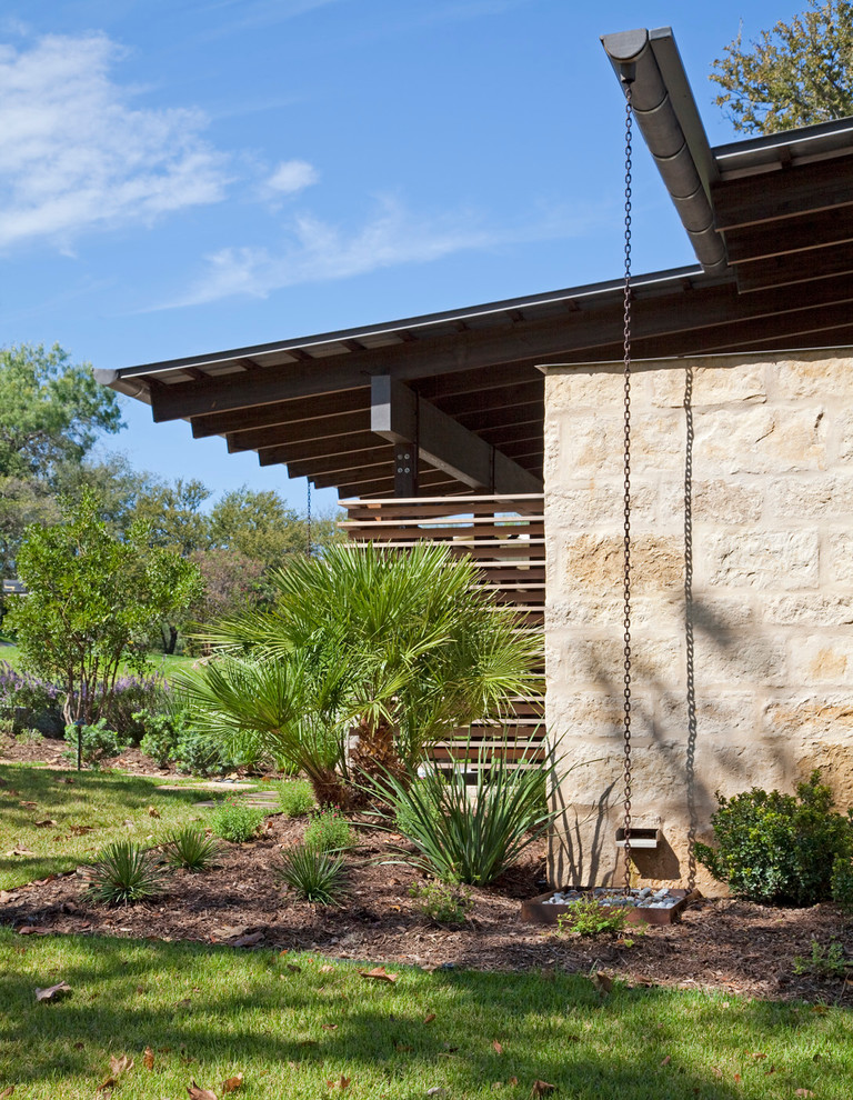 Medium sized and brown modern two floor house exterior in Austin with stone cladding.