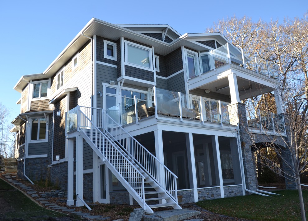 Large beach style gray three-story mixed siding exterior home photo in Calgary