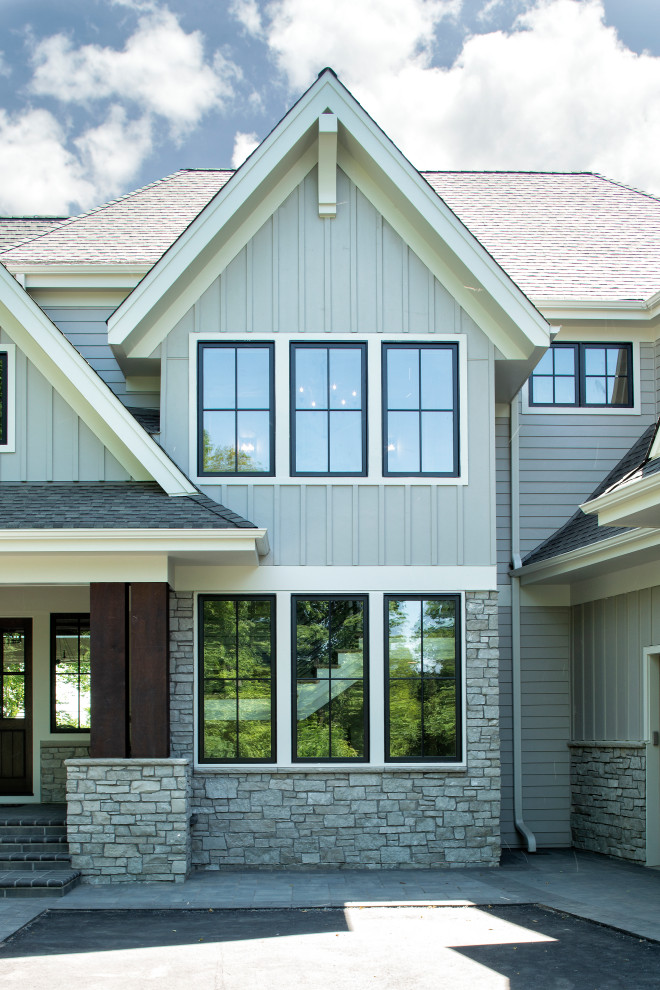 Modelo de fachada de casa gris clásica renovada grande de dos plantas con revestimientos combinados, tejado a dos aguas y tejado de teja de madera