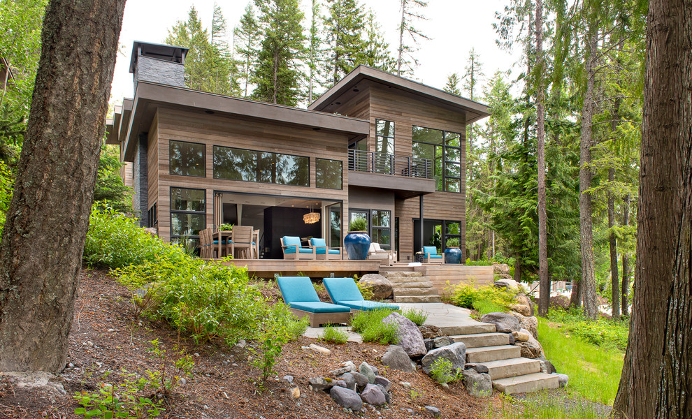 Стильный дизайн: двухэтажный, деревянный, коричневый частный загородный дом в стиле рустика с односкатной крышей - последний тренд