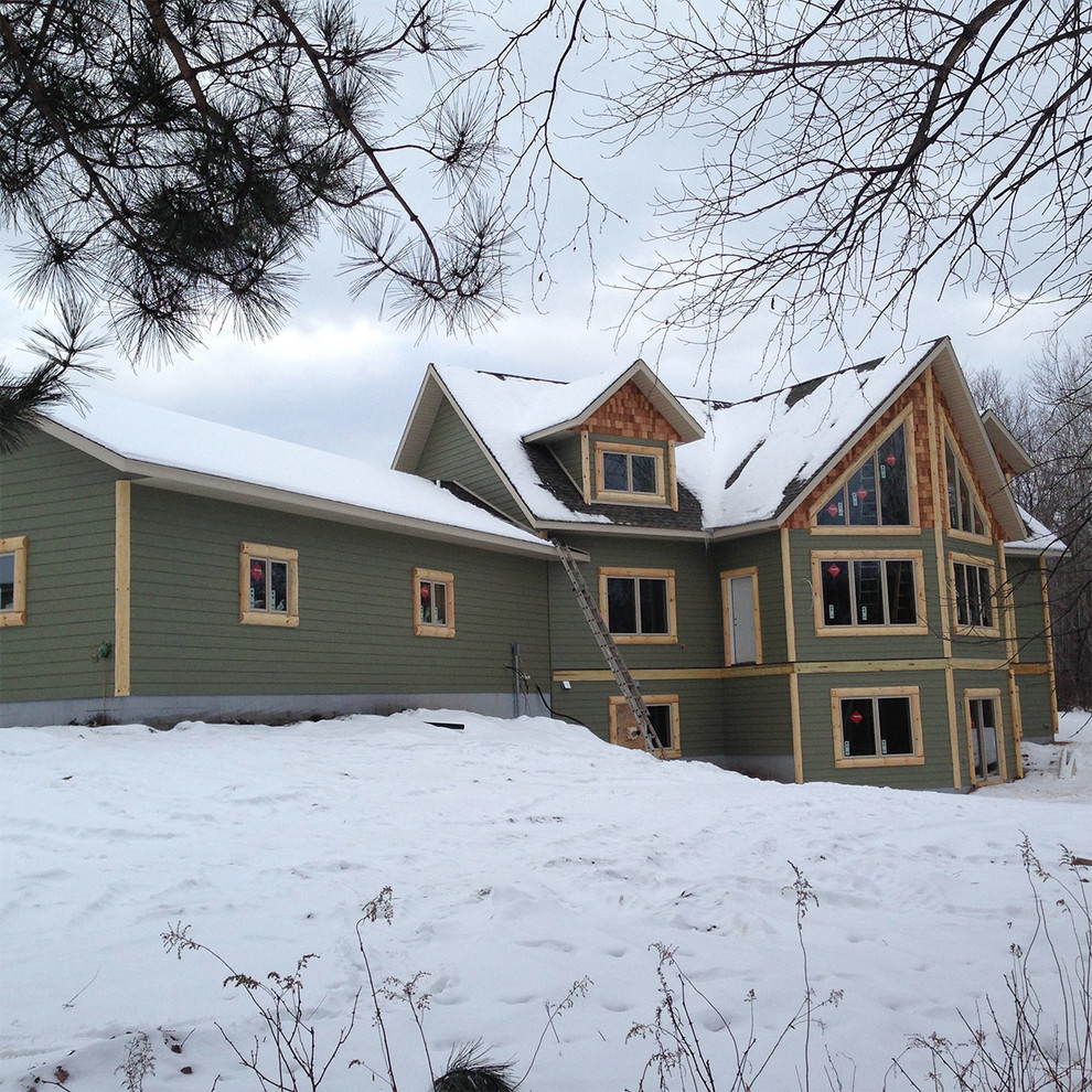 Inspiration for a large rustic green two-story mixed siding gable roof remodel in Minneapolis