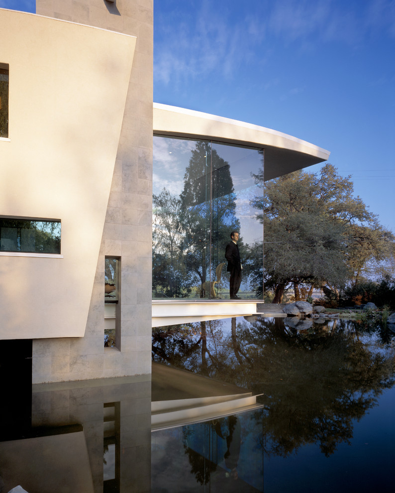 Inspiration pour une grande façade de maison grise minimaliste en béton de plain-pied avec un toit plat.