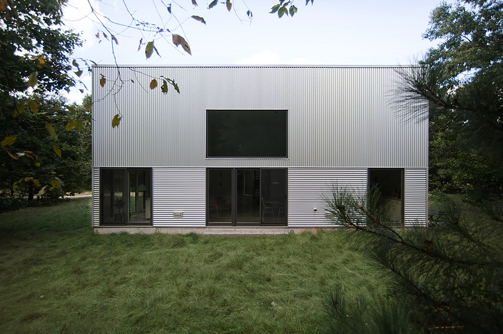 Modelo de fachada gris contemporánea grande de dos plantas con revestimiento de metal y tejado plano