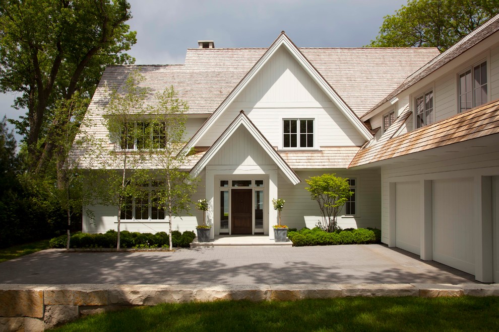 Diseño de fachada blanca clásica renovada de dos plantas con tejado a dos aguas y revestimiento de madera