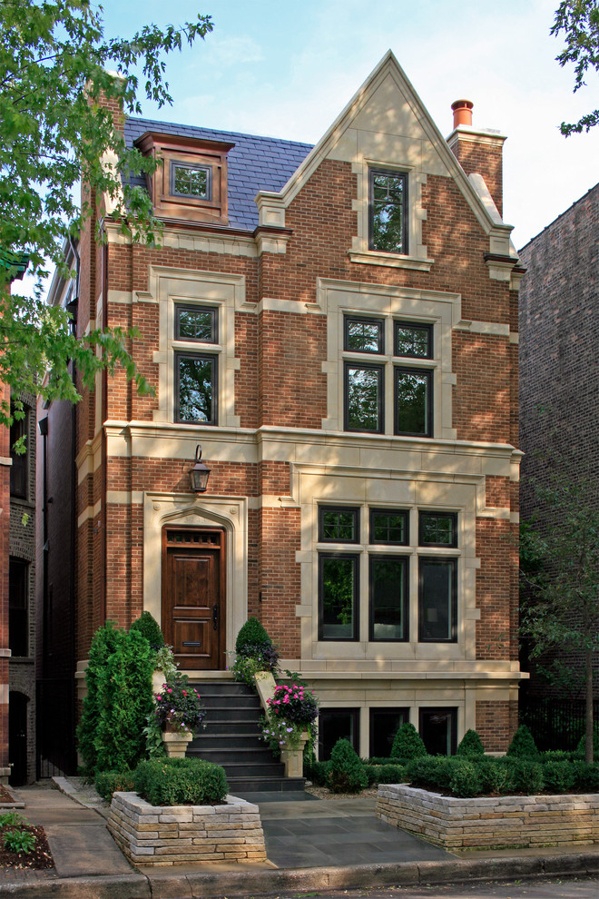 This is an example of an expansive and brown traditional brick house exterior in Chicago with three floors.