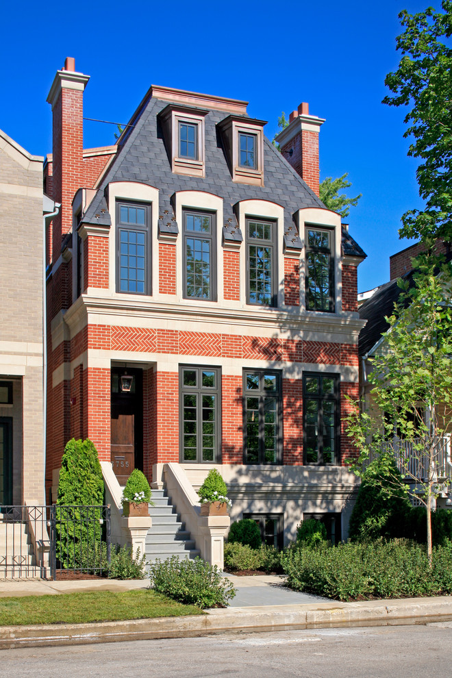Large and red victorian brick house exterior in Chicago with three floors.