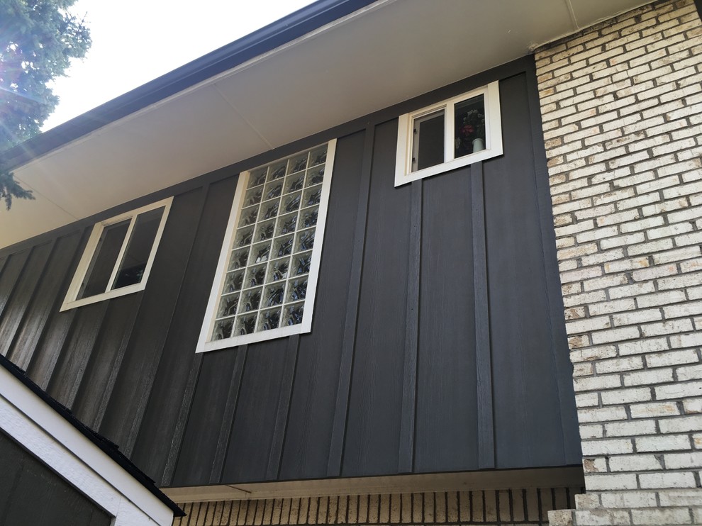 Cette photo montre une façade de maison marron rétro en panneau de béton fibré de taille moyenne et à niveaux décalés.