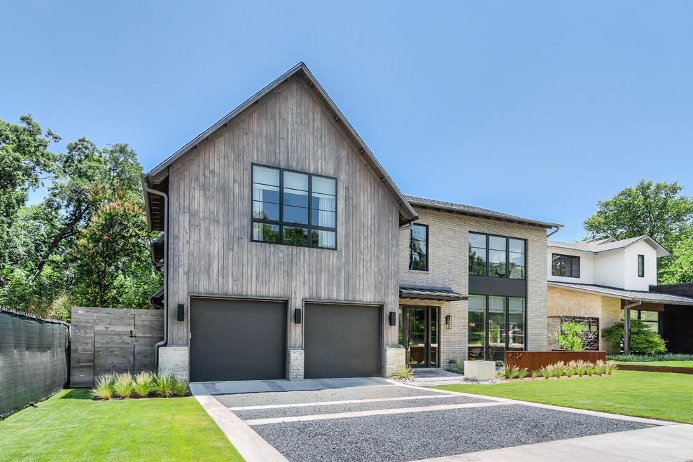 Cette image montre une grande façade de maison grise design à un étage avec un revêtement mixte et un toit à deux pans.