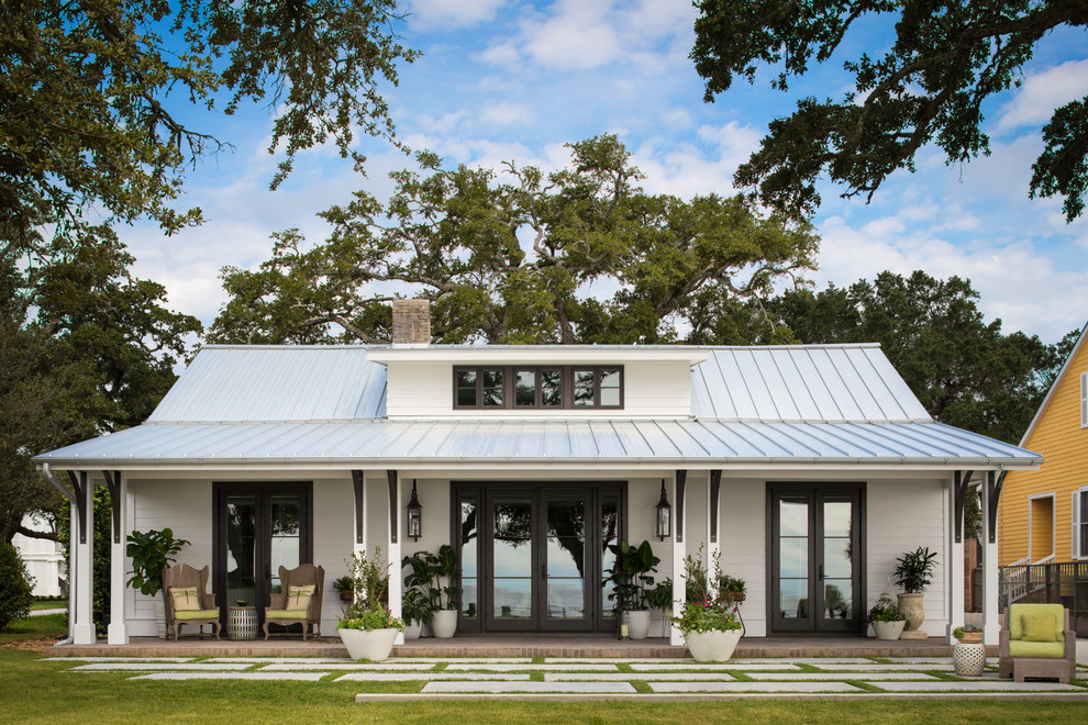 Imagen de fachada de casa blanca tradicional renovada de tamaño medio de una planta con revestimiento de madera y tejado de metal