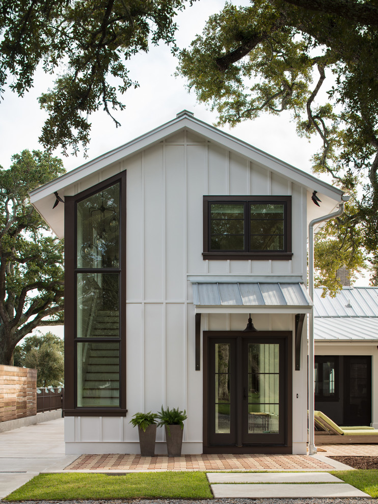 Imagen de fachada de casa blanca tradicional renovada de tamaño medio de una planta con revestimiento de madera y tejado de metal