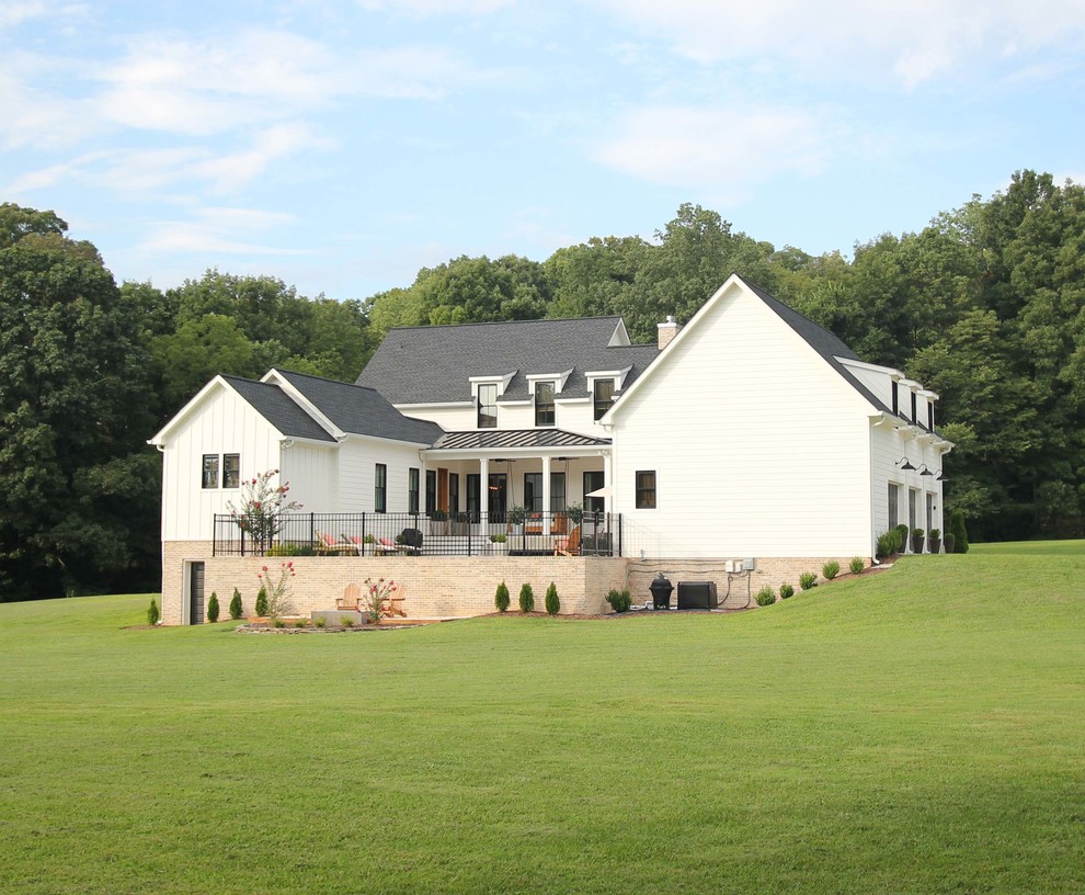 Mittelgroßes, Zweistöckiges Landhausstil Einfamilienhaus mit Faserzement-Fassade, weißer Fassadenfarbe, Satteldach und Misch-Dachdeckung in Sonstige