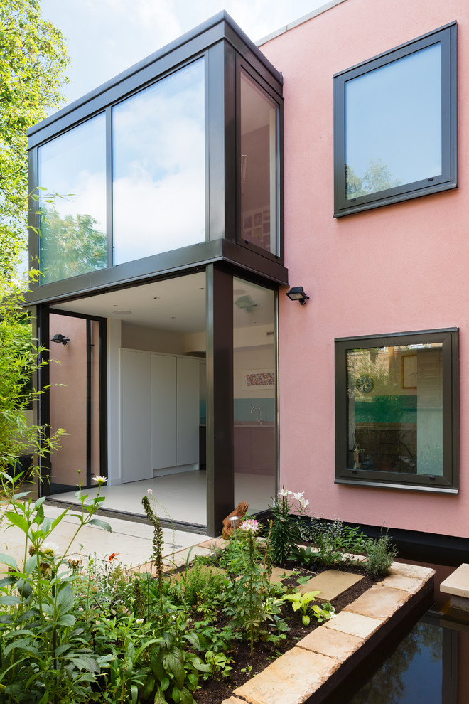 Photo of a contemporary rear extension in London with a pink house.