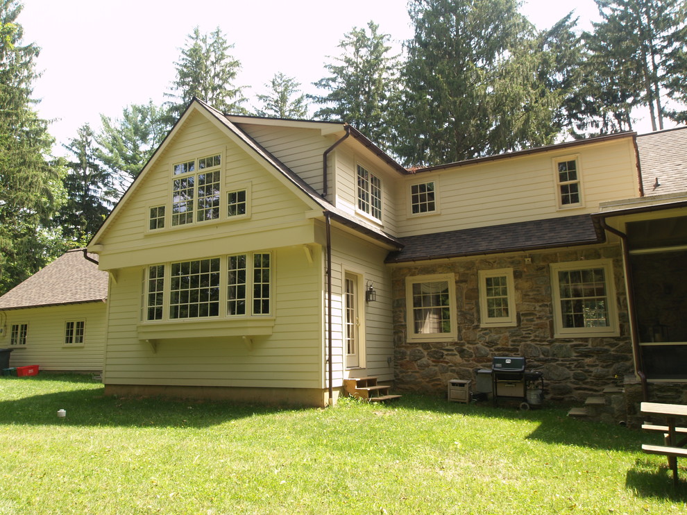 Example of a large classic beige two-story mixed siding gable roof design in Other