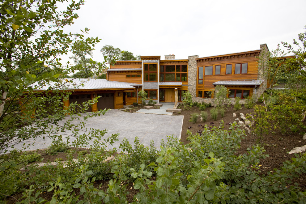 Diseño de fachada marrón contemporánea de dos plantas con revestimiento de madera