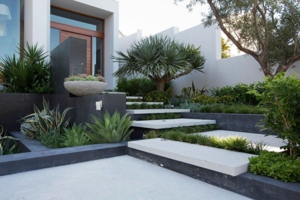 Cette image montre une façade de maison grise design en béton de taille moyenne et de plain-pied avec un toit plat.
