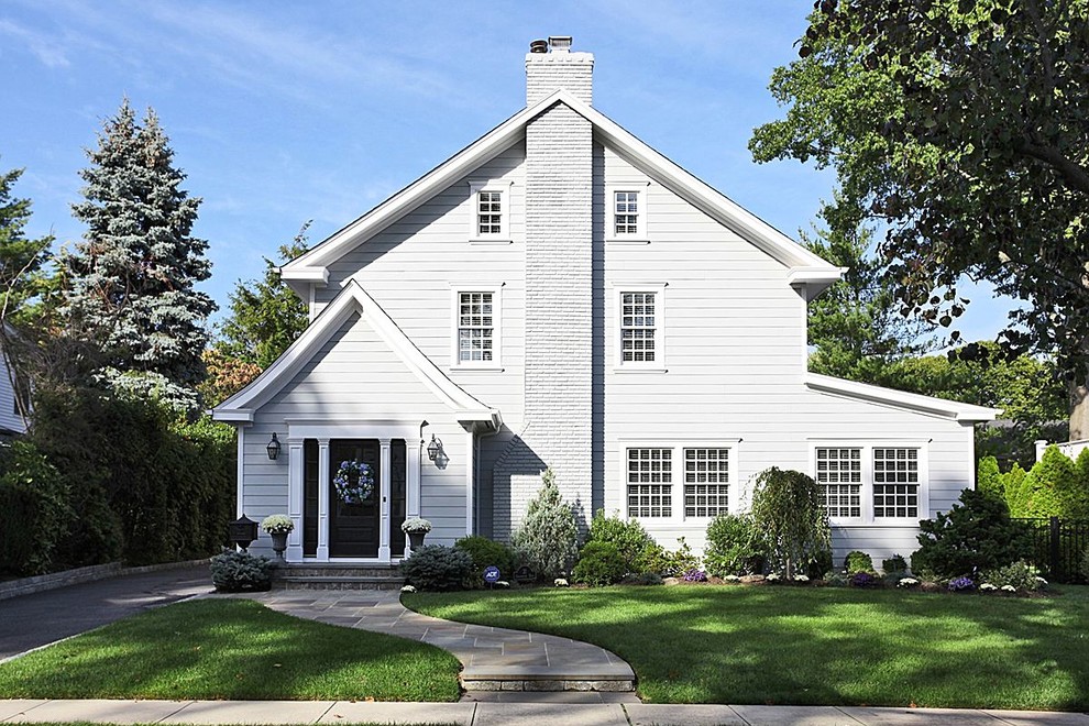 Cette photo montre une grande façade de maison blanche chic en panneau de béton fibré à deux étages et plus avec un toit à deux pans et un toit en shingle.