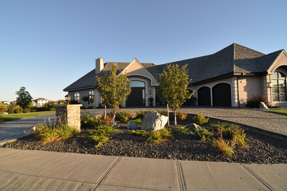 Large elegant beige one-story stucco exterior home photo in Other with a shingle roof