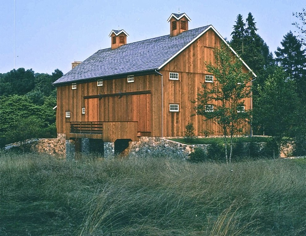 Стильный дизайн: большой, трехэтажный, деревянный, коричневый дом в стиле кантри с двускатной крышей - последний тренд