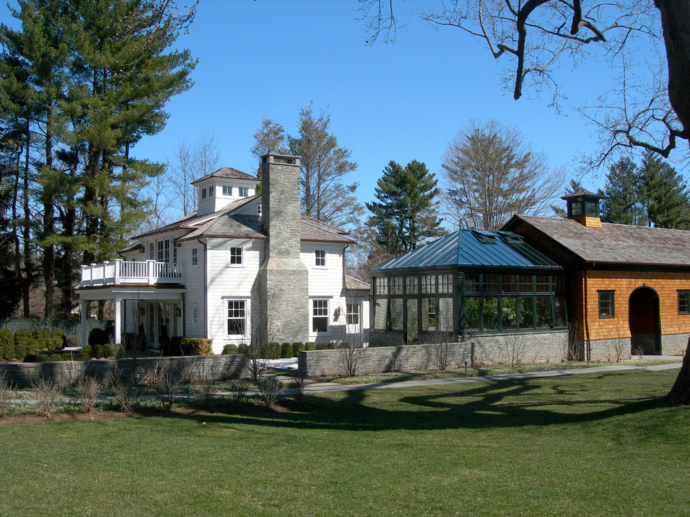 Foto della facciata di una casa grande bianca eclettica a tre piani con rivestimento in vinile e tetto a padiglione