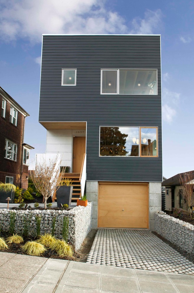 Cette photo montre une façade de maison noire tendance à deux étages et plus avec un toit plat.