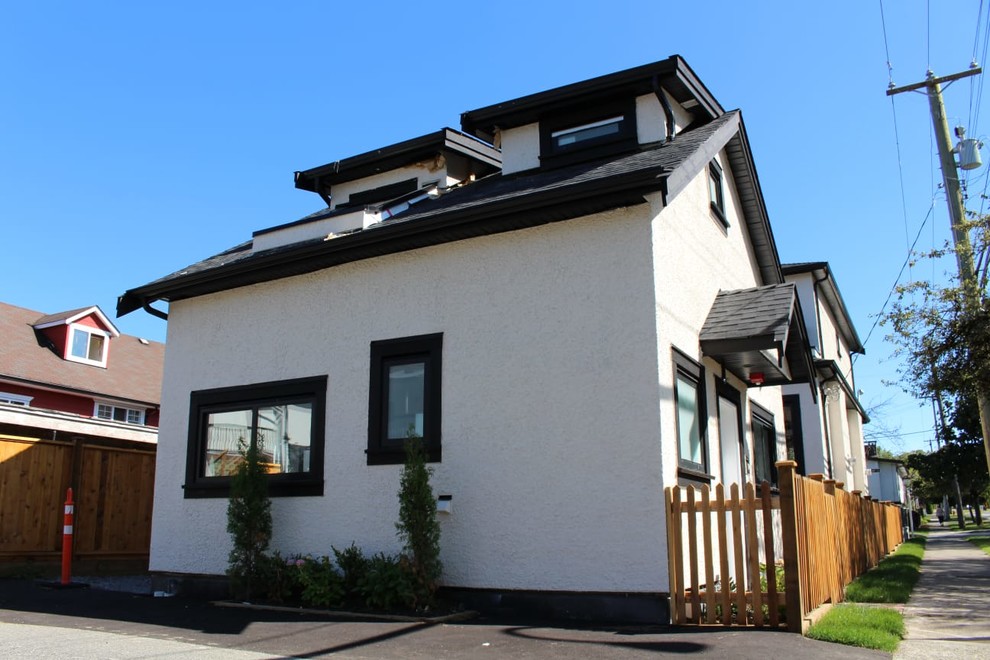 Inspiration pour une petite façade de maison grise design en stuc à un étage avec un toit à deux pans et un toit en shingle.